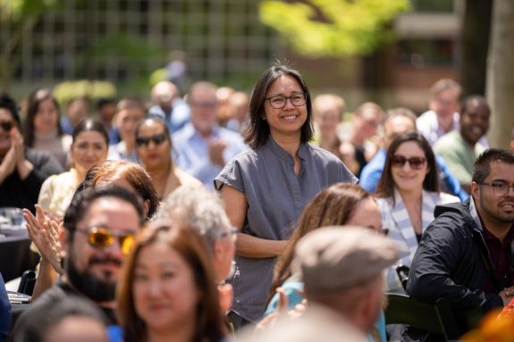 staff standing up in crowd of seated peers to receive award